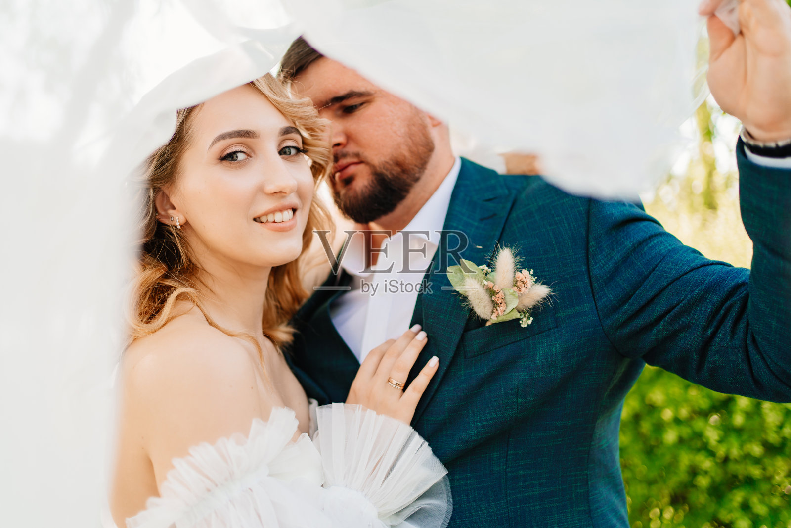 面纱下的恋人和幸福的新娘和新郎的肖像。照片摄影图片