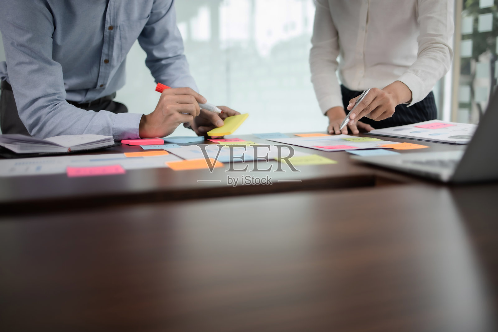 在现代化的办公环境中，创业团队讨论战略工作过程。照片摄影图片