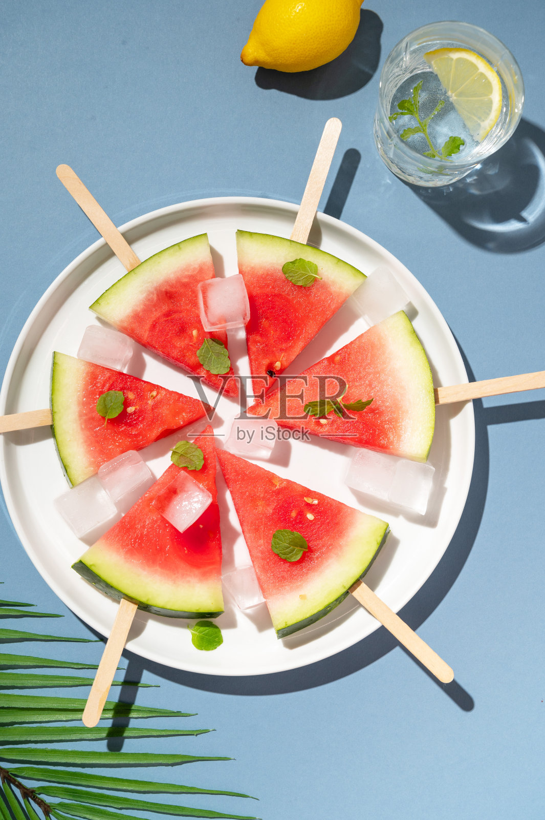 新鲜的西瓜冰棍和冰块放在盘子里。夏季抽象食品。照片摄影图片