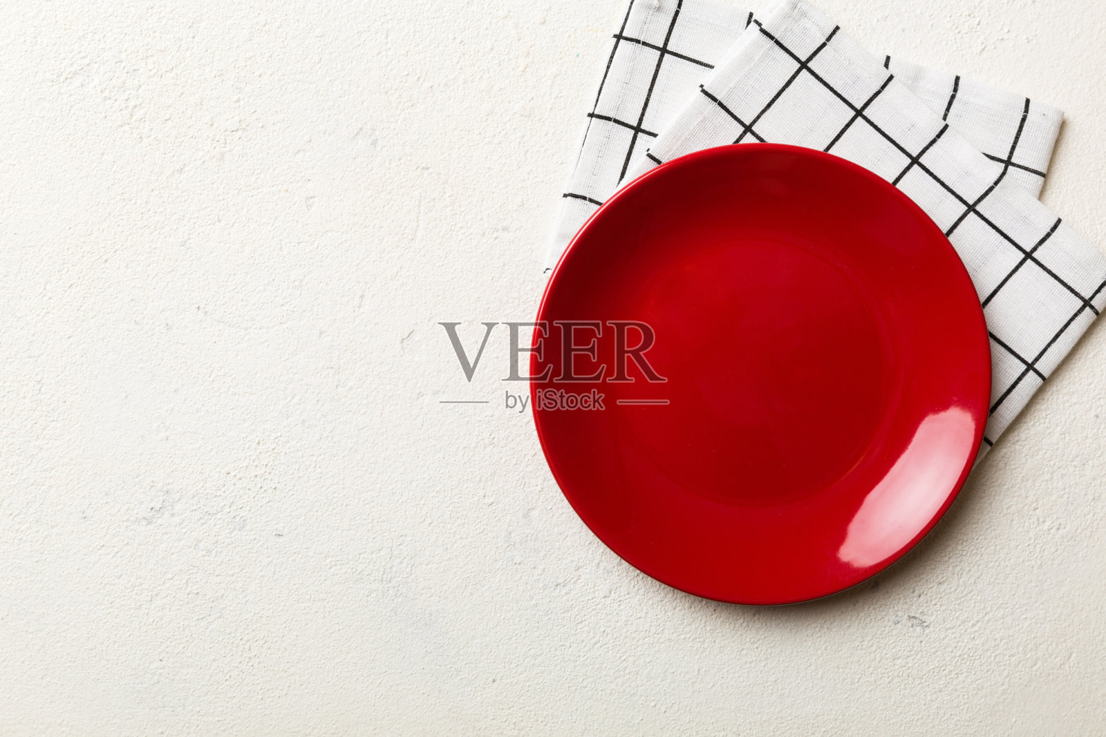 俯视图上的彩色背景空圆形红色盘子桌布上的食物。在餐巾纸上空出盘子，为你的设计留出空间照片摄影图片