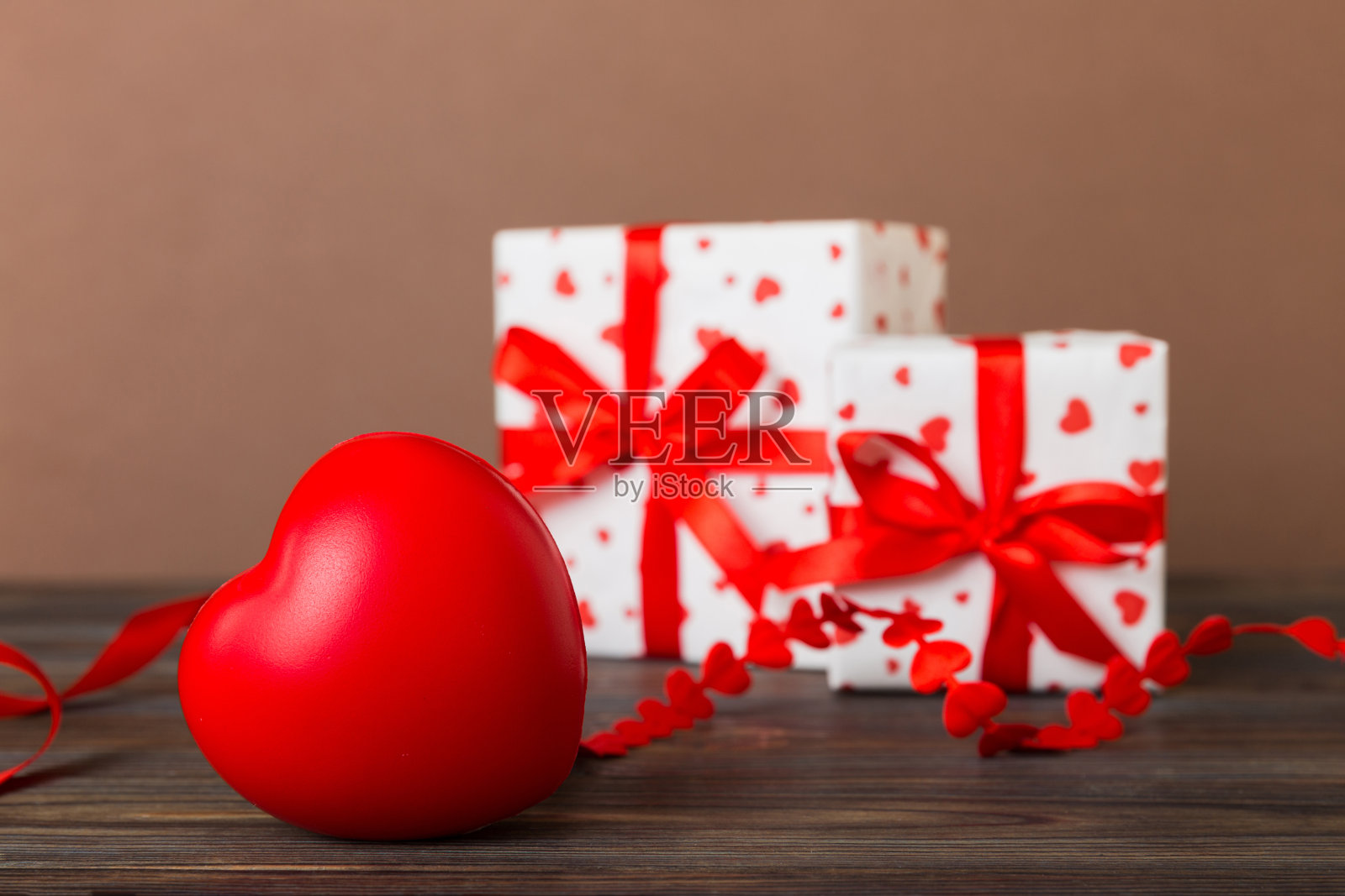 礼盒与红色蝴蝶结和红色心形的彩色背景。透视图。平躺照片摄影图片