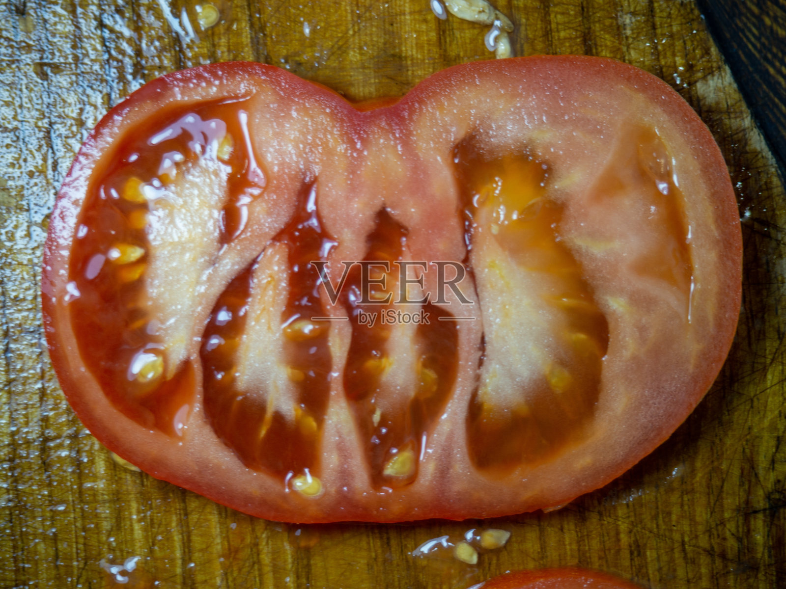 把番茄切片放在砧板上。西红柿圈。蔬菜零食特写。新鲜成熟的蔬菜。照片摄影图片