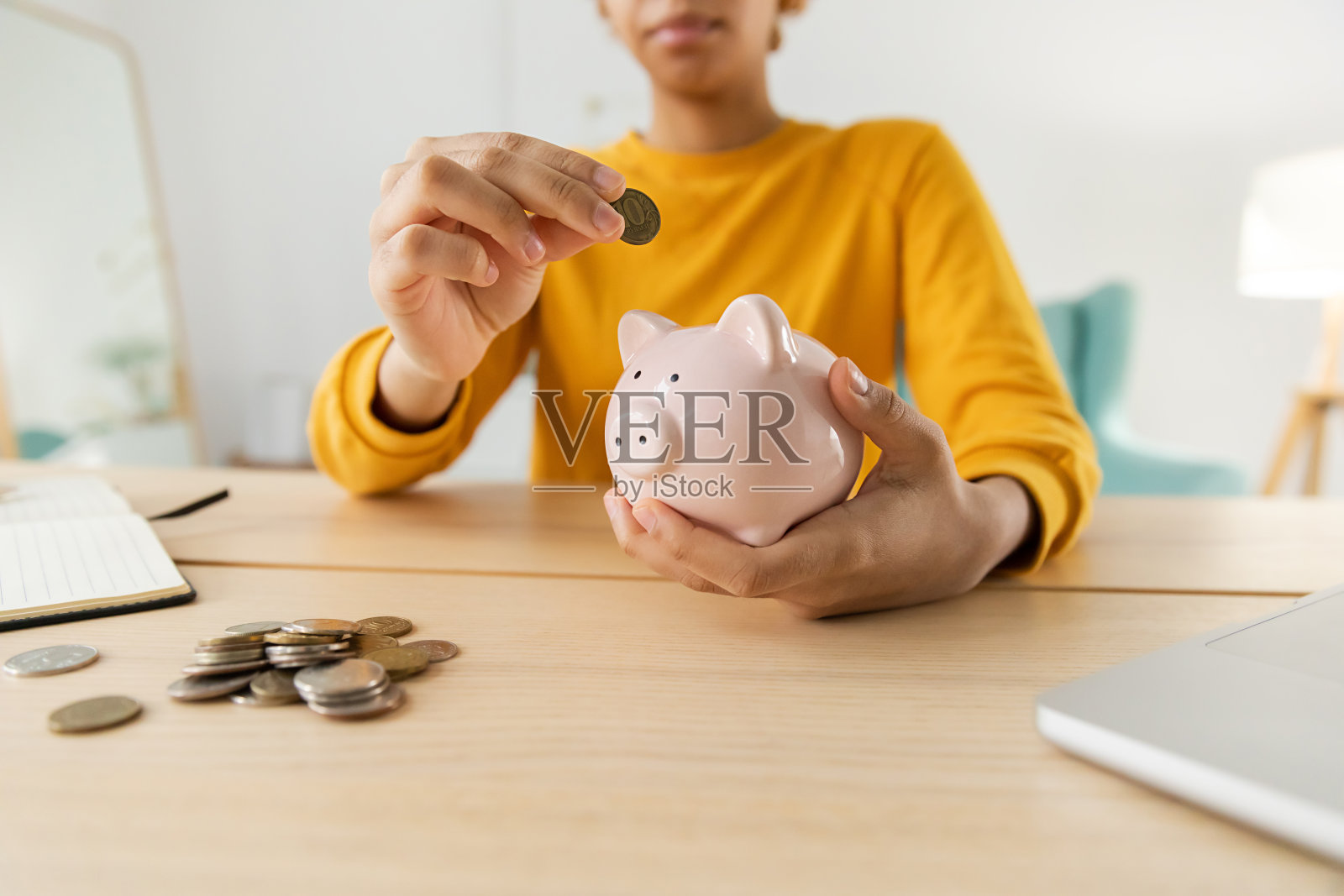 为将来存钱投资。非裔美国女孩拿着粉红色的小猪存钱罐，把钱硬币。储蓄投资预算业务财富退休金融货币银行概念。照片摄影图片