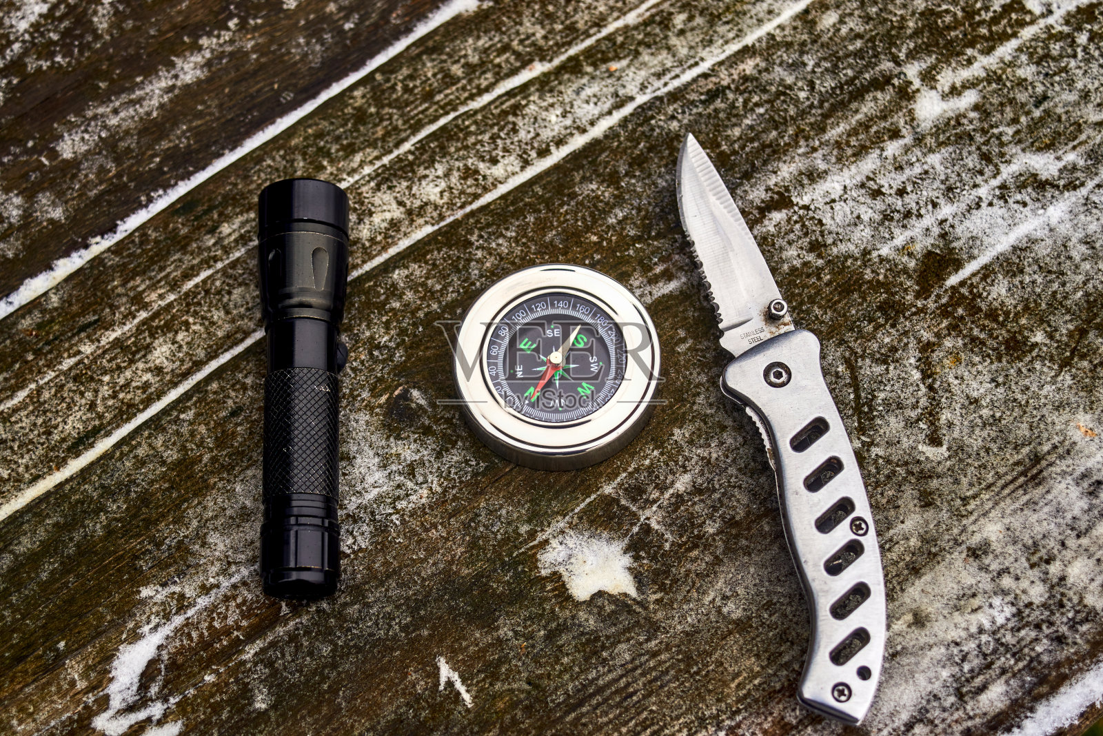 手电筒、指南针和木头上的刀照片摄影图片