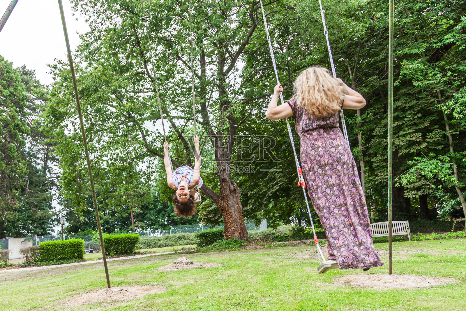 在儿童秋千上荡秋千的漂亮中年夫妇照片摄影图片