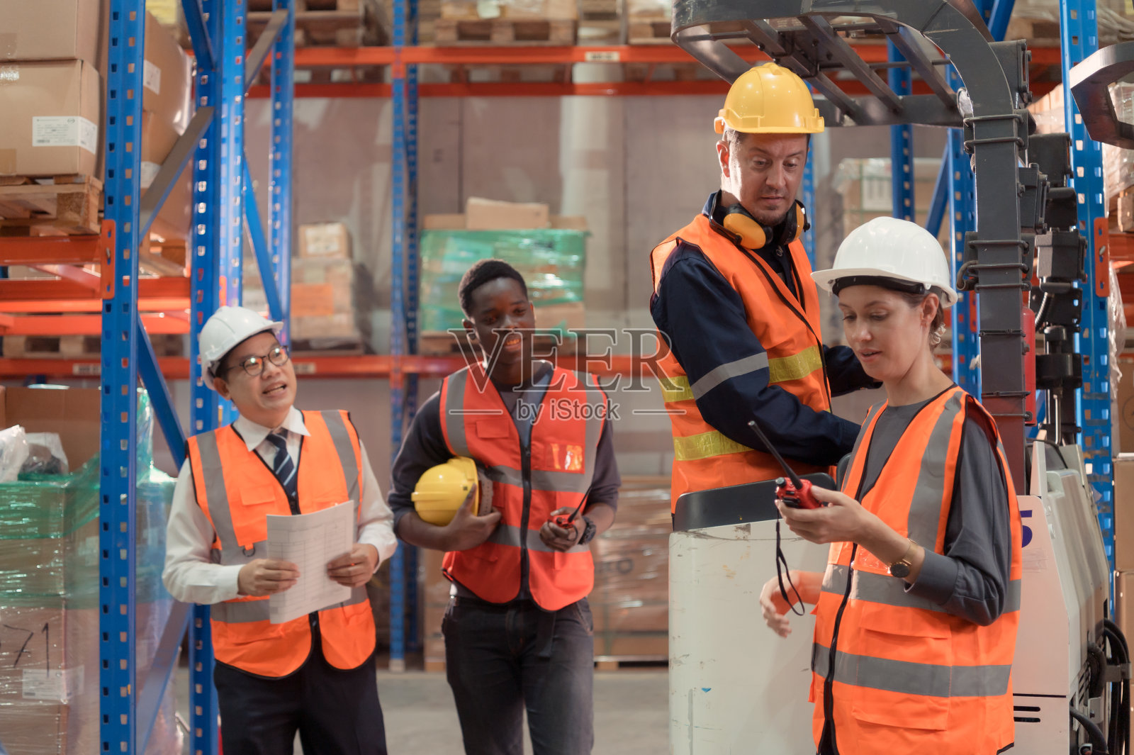 经理、工头和仓库工人一起商量今晚把货物出库，完成给小商户的发货。照片摄影图片