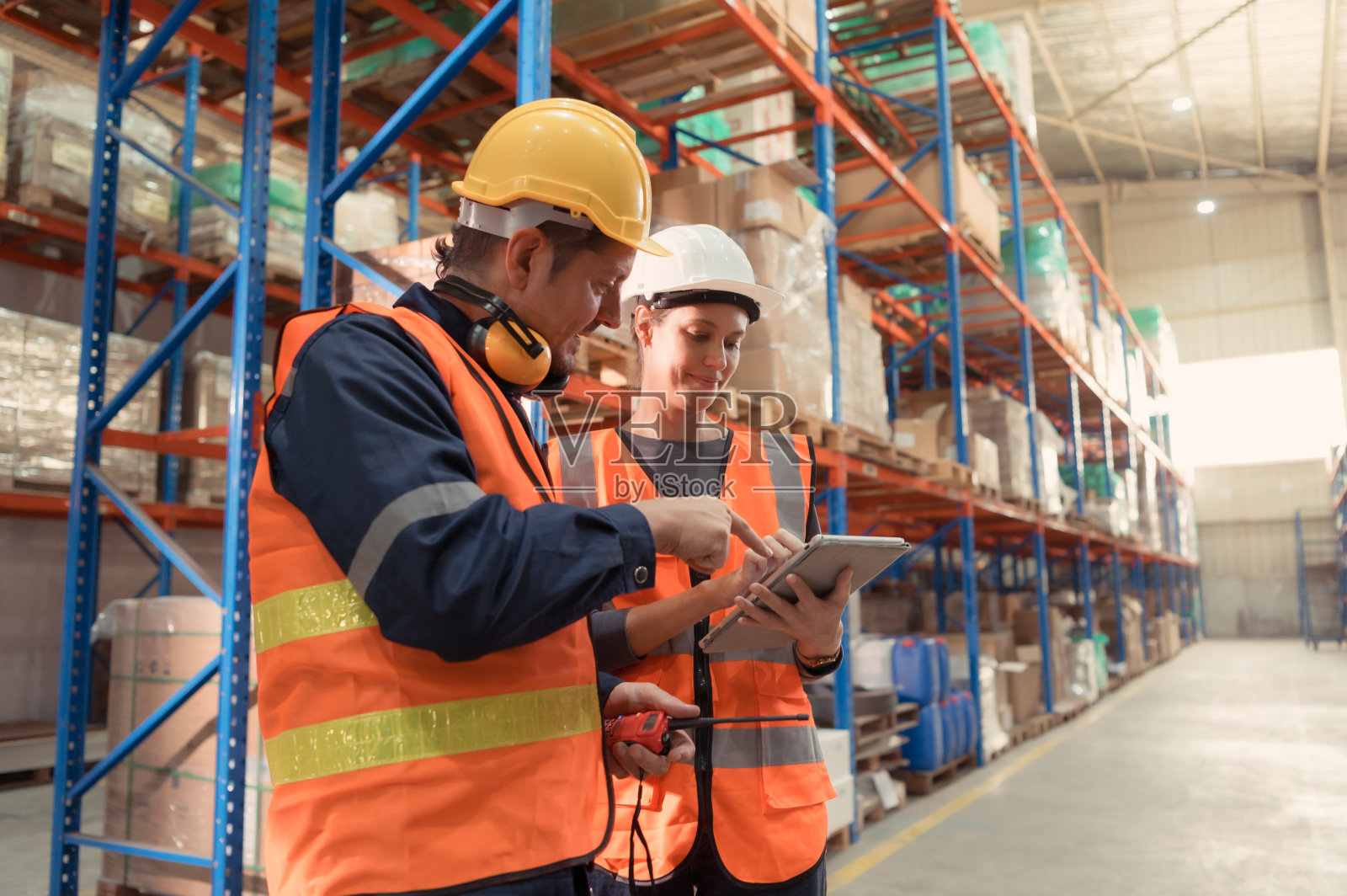 经理将报告交给领班，共同检查需要带入中央仓库的货物。然后发送到各个区域配送中心。照片摄影图片