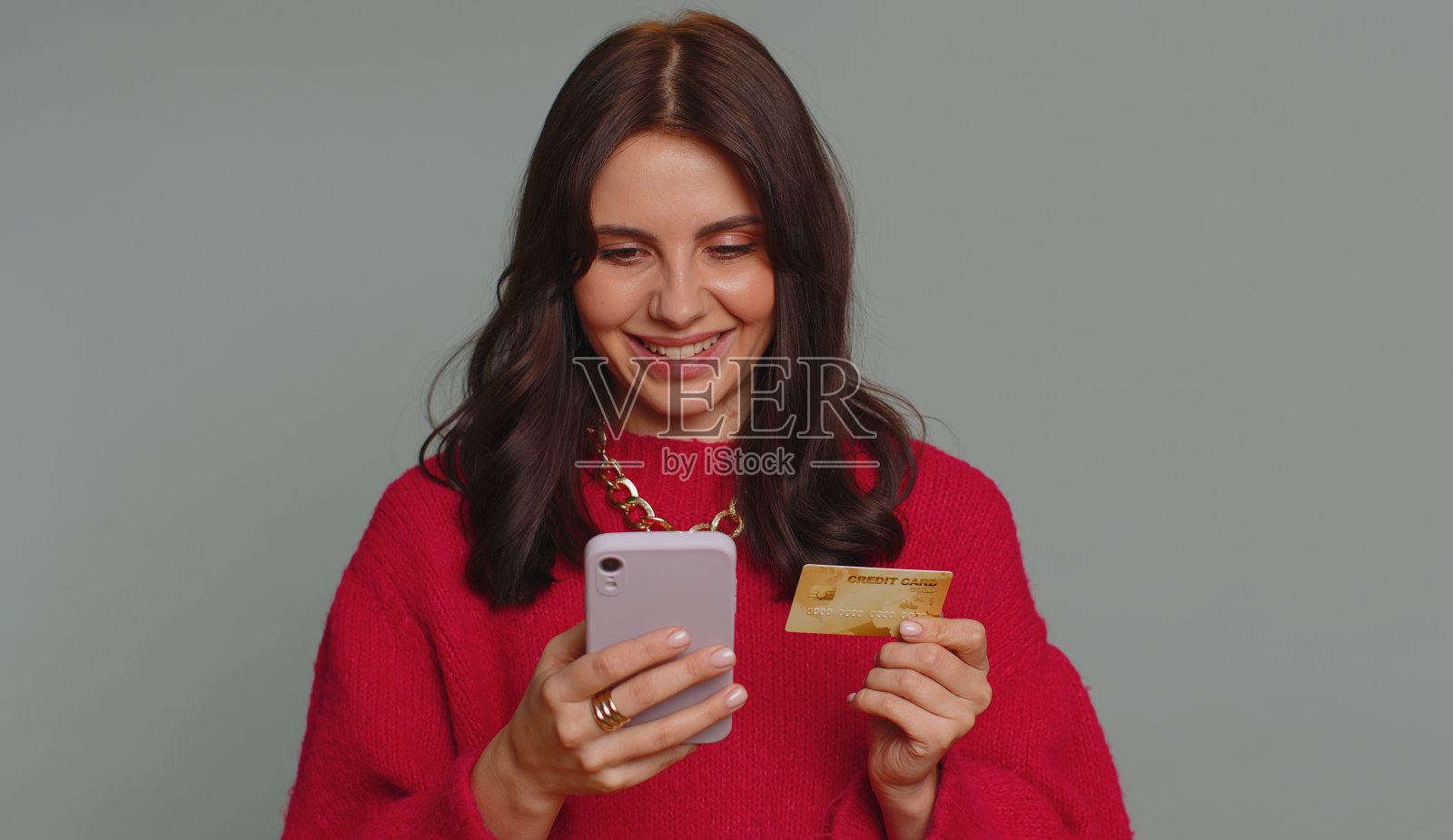 年轻女子在网上购物时使用信用卡和智能手机转账照片摄影图片