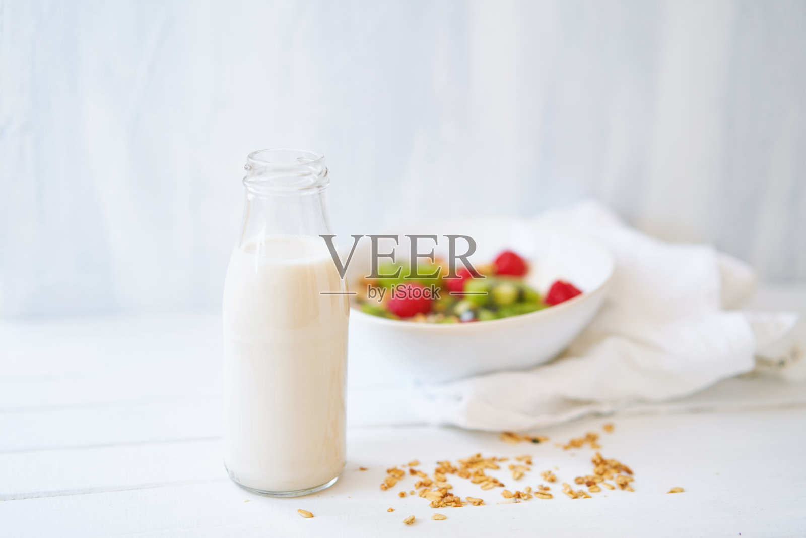 白色桌子上有燕麦牛奶的小瓶照片摄影图片