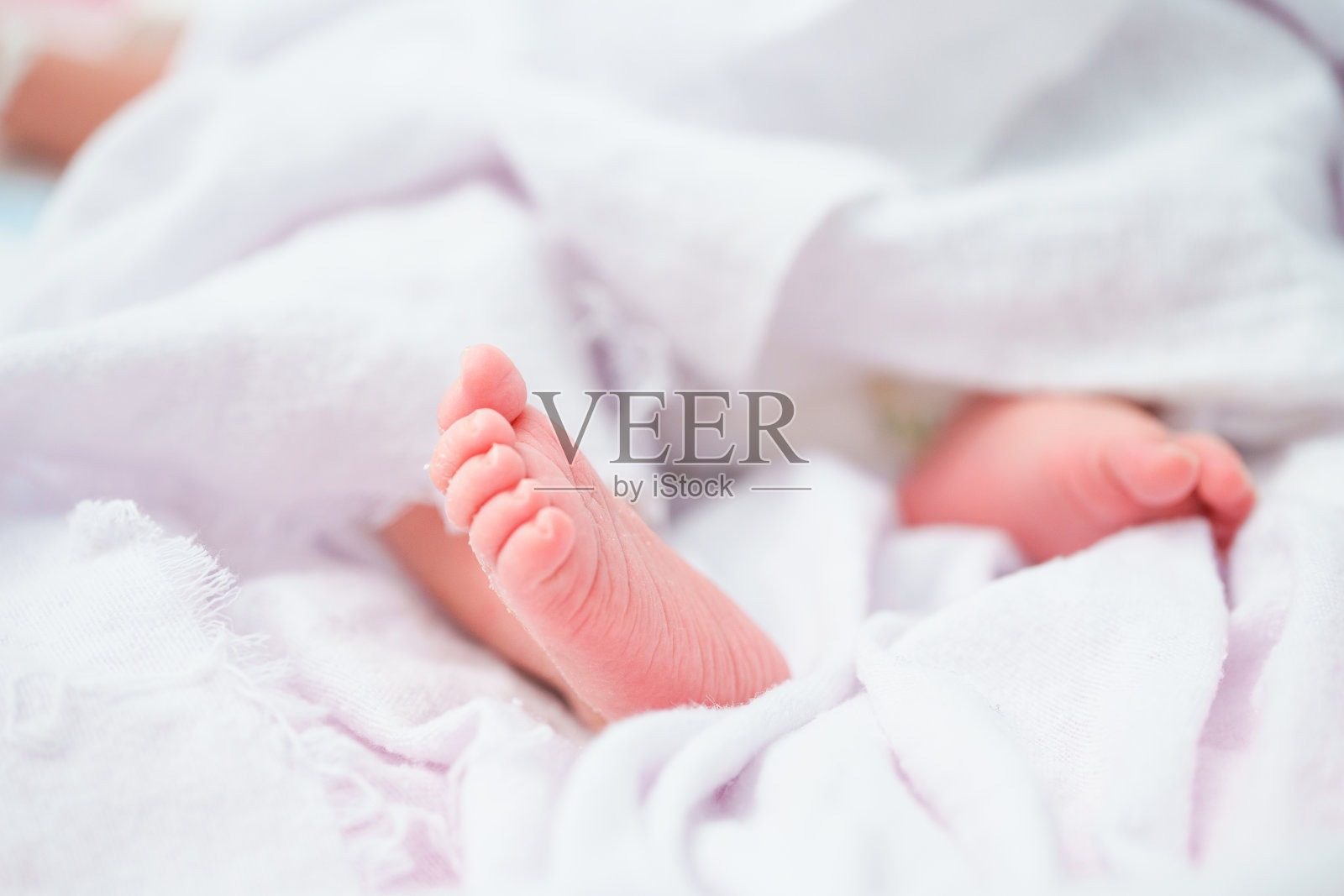 一个刚出生的亚洲女婴的肖像睡在床上，可爱的胖娃5天。照片摄影图片