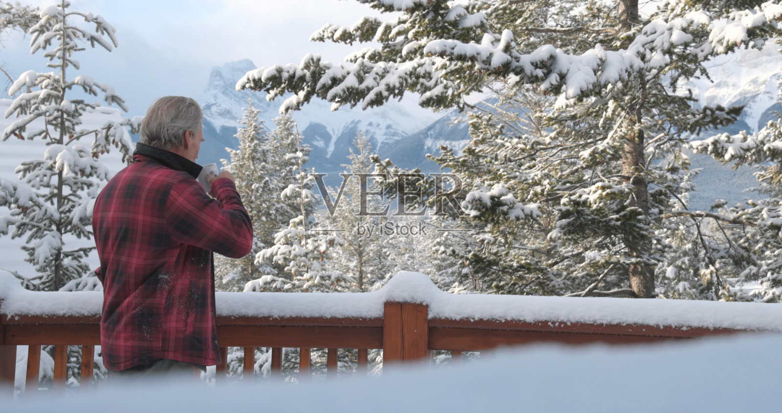 成熟男子在小屋阳台上享受热饮照片摄影图片