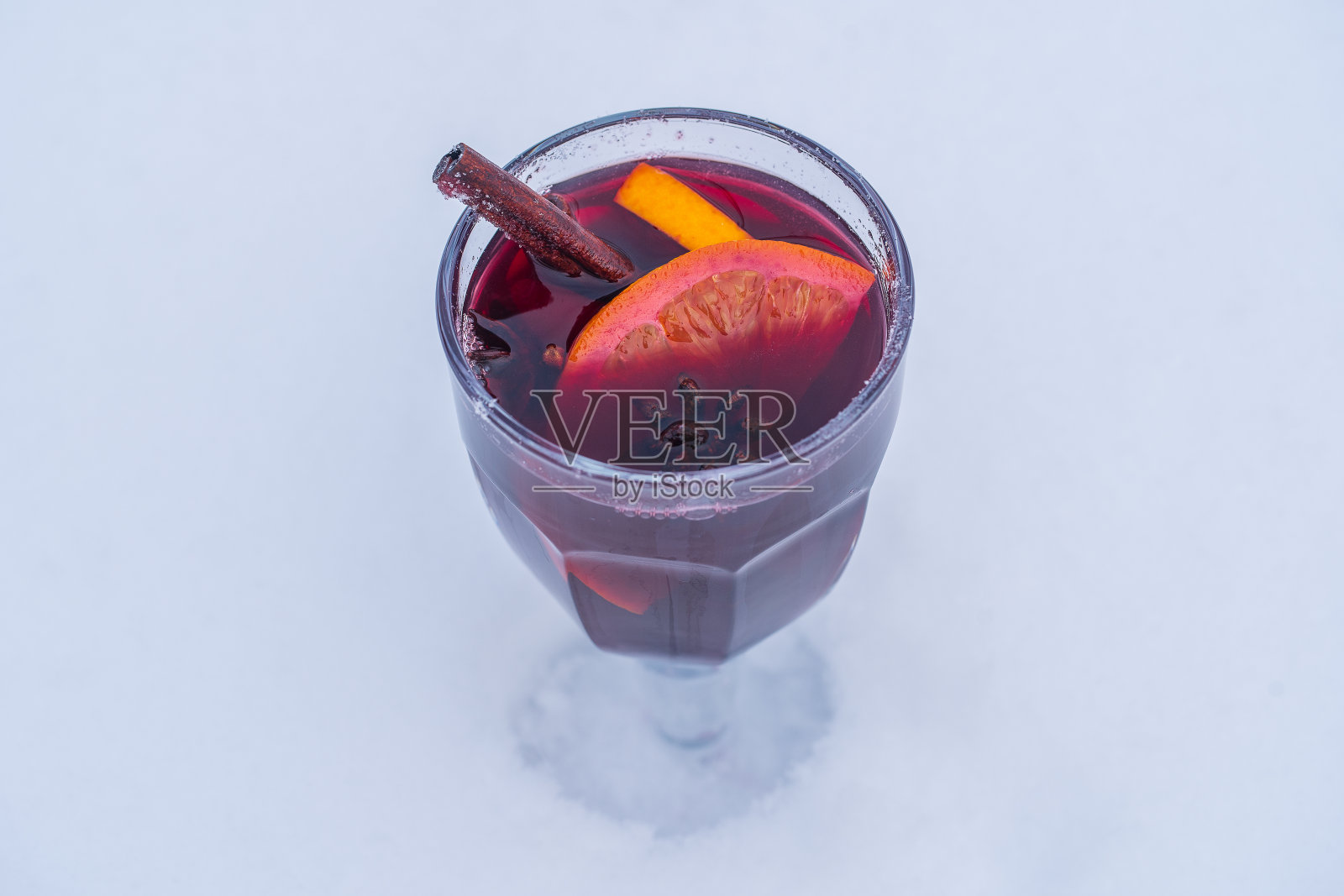 玻璃杯与热红酒在床上的雪和白色的背景，近。圣诞节的饮料照片摄影图片