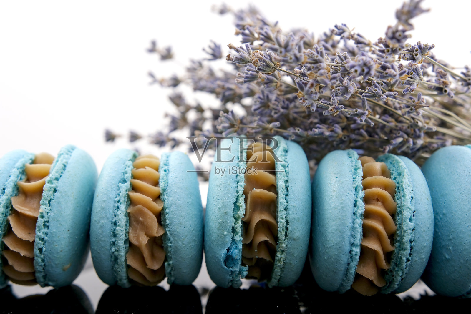 法式马卡龙，薰衣草风味，瓷砖背景上有新鲜的薰衣草花，大理石背景上有各种各样的马卡龙。时尚的安排甜美。平铺，俯视图。照片摄影图片