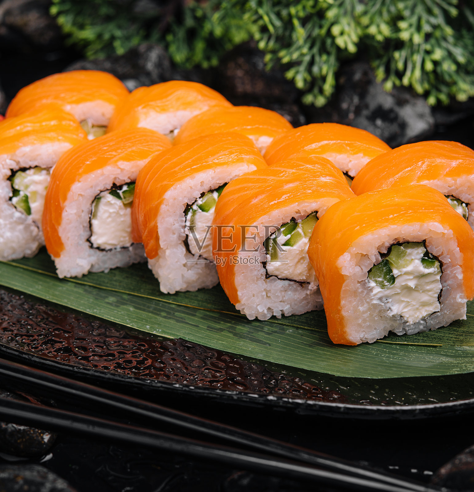 三文鱼寿司配黑盘米饭照片摄影图片