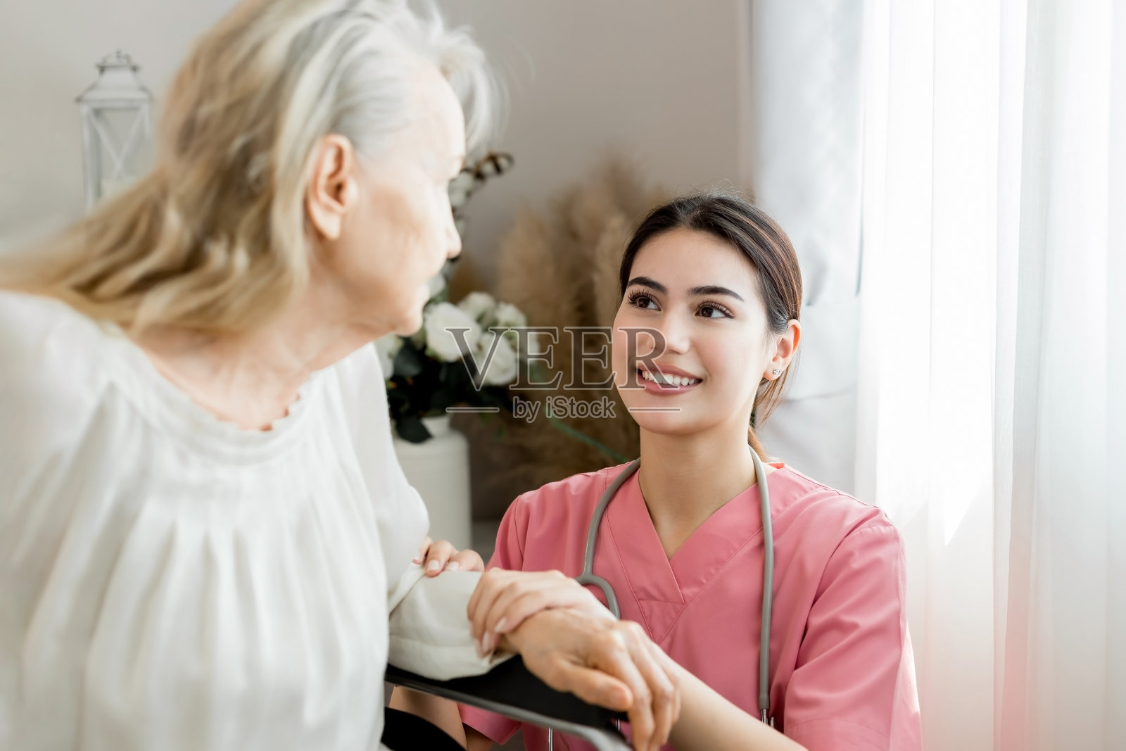 白人护理女士为老年妇女病人咨询。轮椅残疾康复和护理在养老院。为老年妇女提供医疗保健支持和护理。照片摄影图片