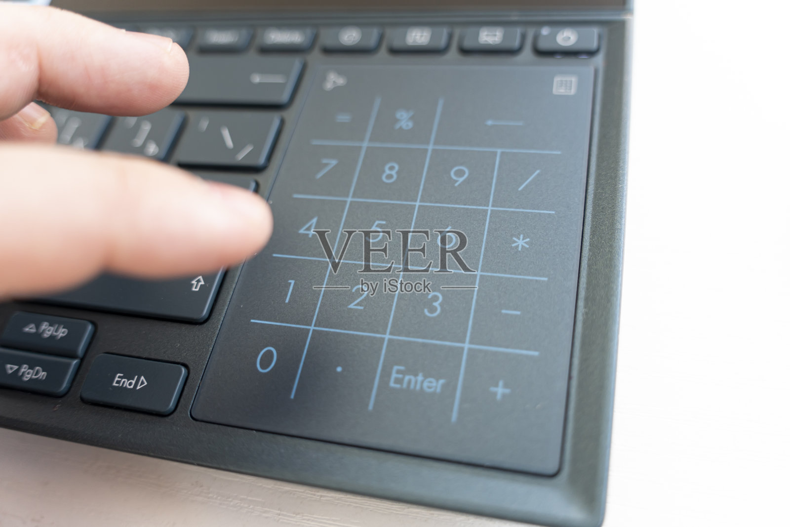 女性食指按0 NUMPAD键。特写镜头。在笔记本电脑键盘上进行财务计算照片摄影图片