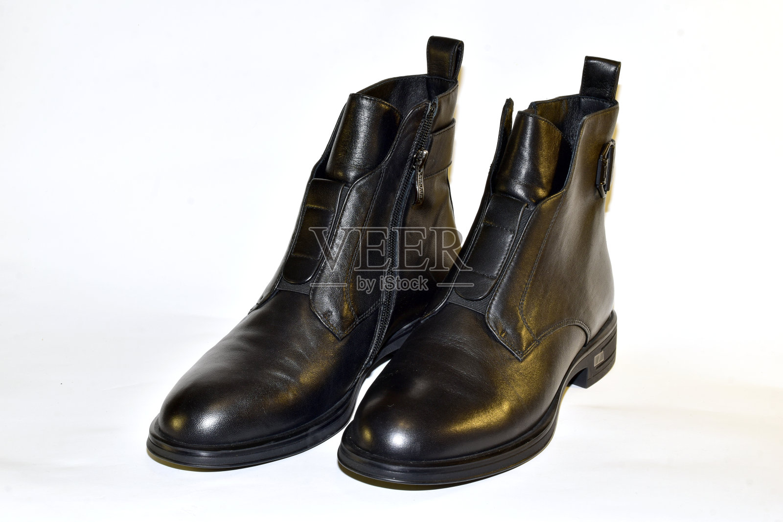 一双女式黑色短靴矗立在白色背景上。照片摄影图片