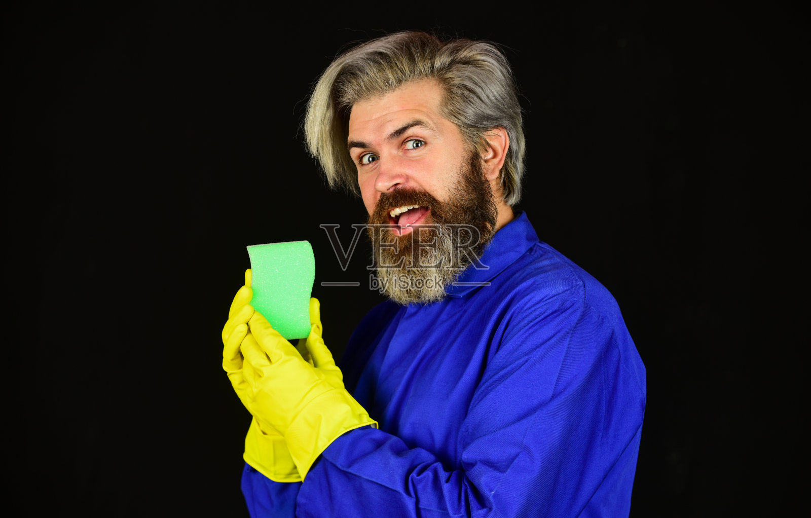 消毒的概念。蓝色制服的大胡子清洁工。春季大扫除。潮人打扫房间。病毒和微生物清除。病毒消毒。清洁家里。保护。男士戴上防护橡胶手套照片摄影图片