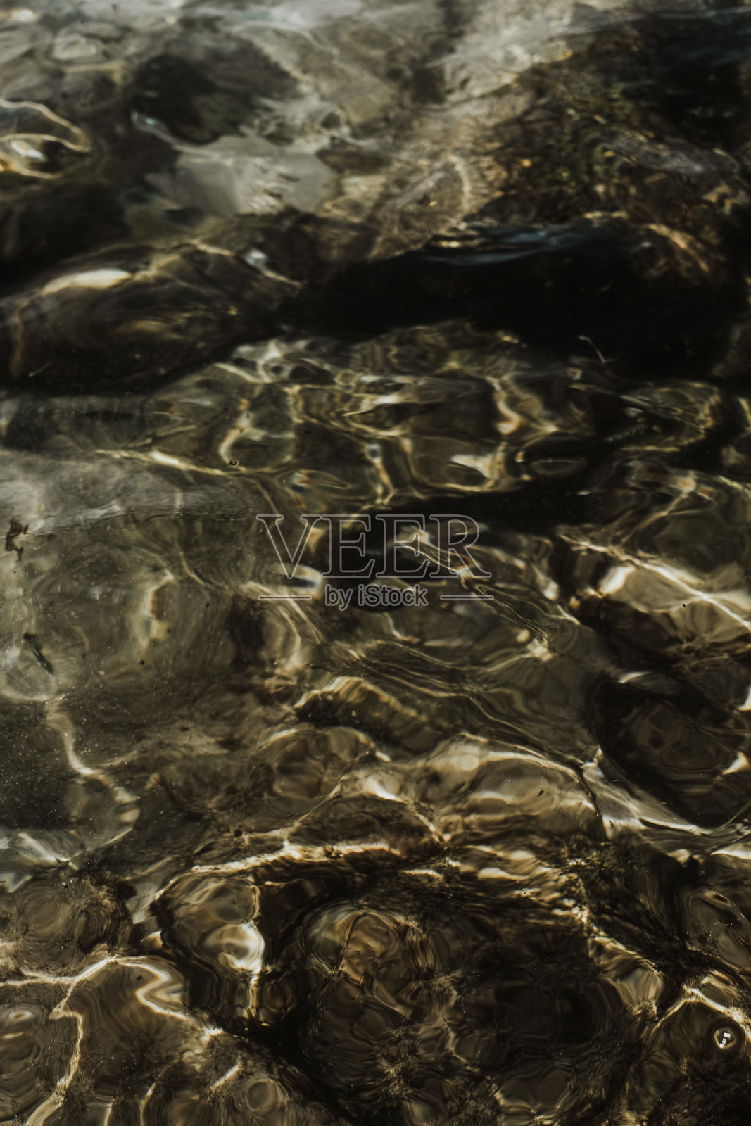 水的纹理与亮点。反射的光。湖与石头背景。夏日海滩的美感。自然透明的。照片摄影图片