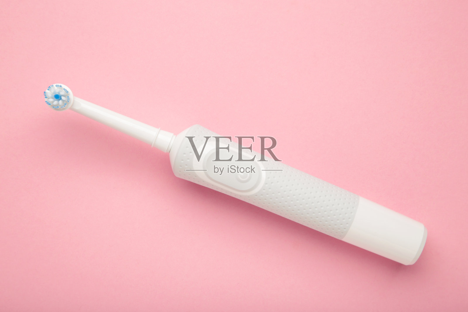 粉色背景的现代电动牙刷。日常口腔护理控制工具。照片摄影图片