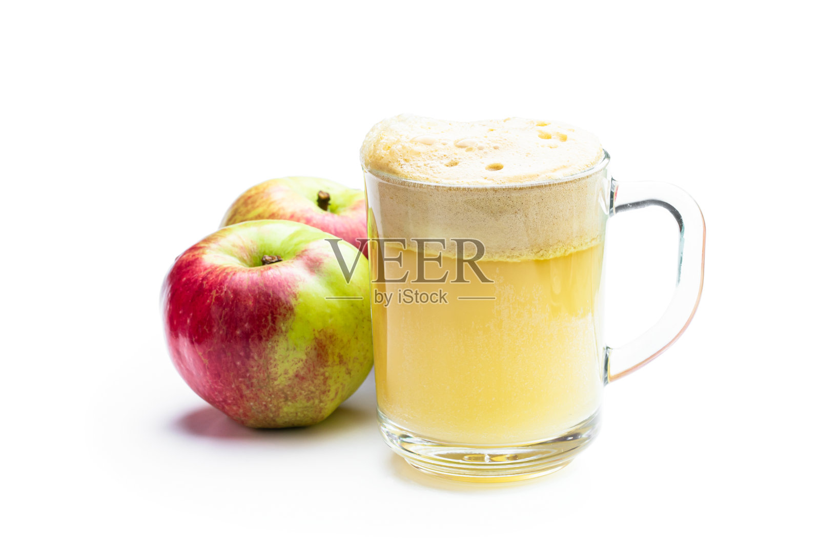 自制鲜榨苹果汁，盛在透明玻璃中，白色隔离照片摄影图片