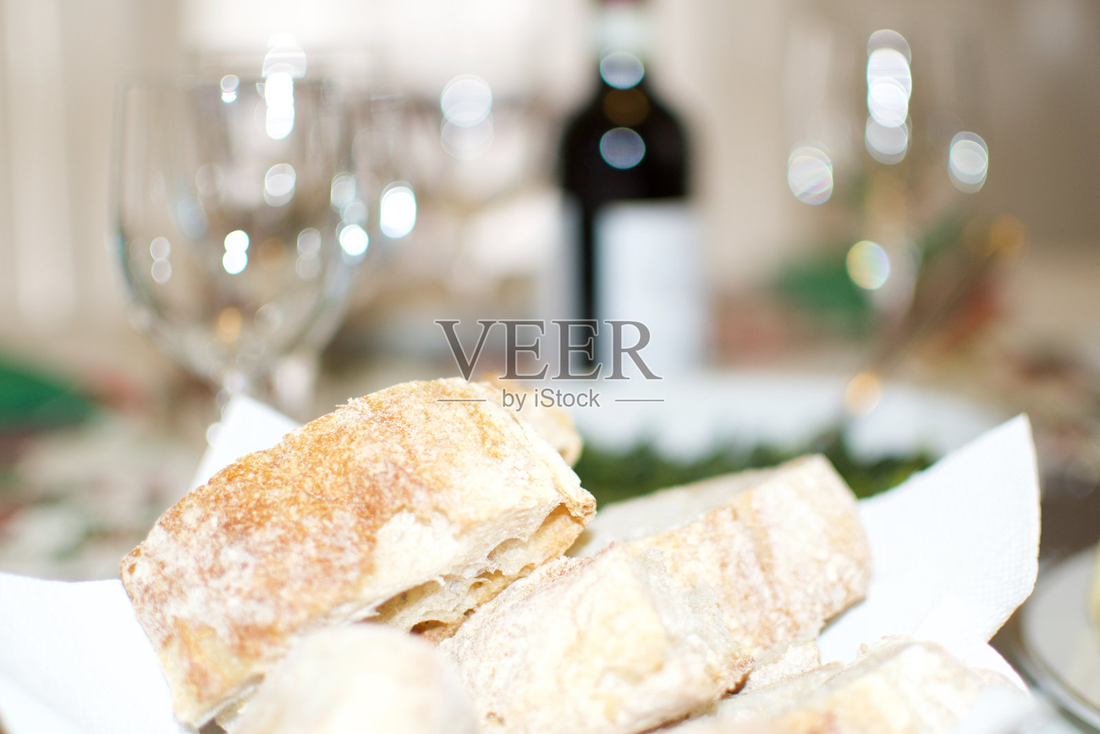 典型的午餐餐桌，有玻璃杯、一瓶酒、面包、蔬菜和传统的意大利风味派照片摄影图片