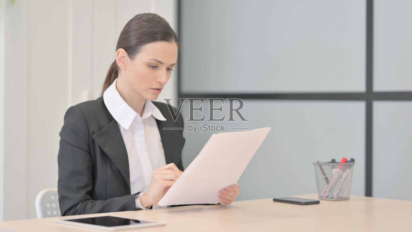 女商人在办公室阅读文件，文书工作照片摄影图片