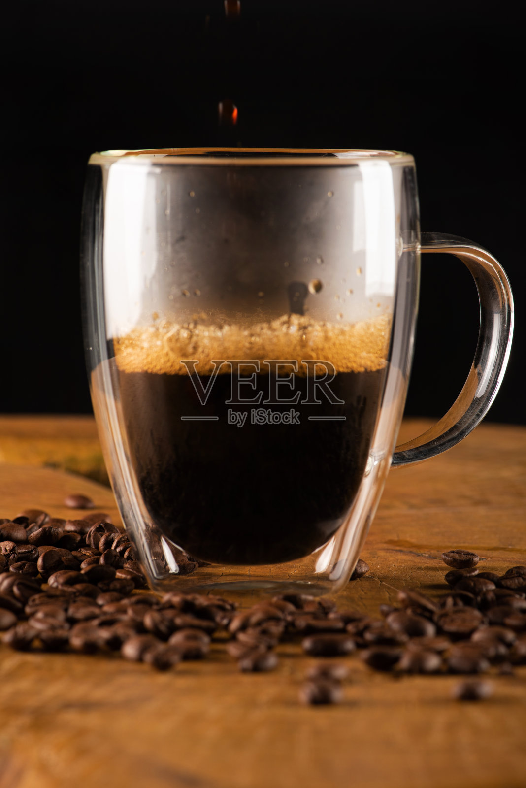 玻璃杯，玻璃杯上的咖啡与质朴的木头，选择性重点。照片摄影图片