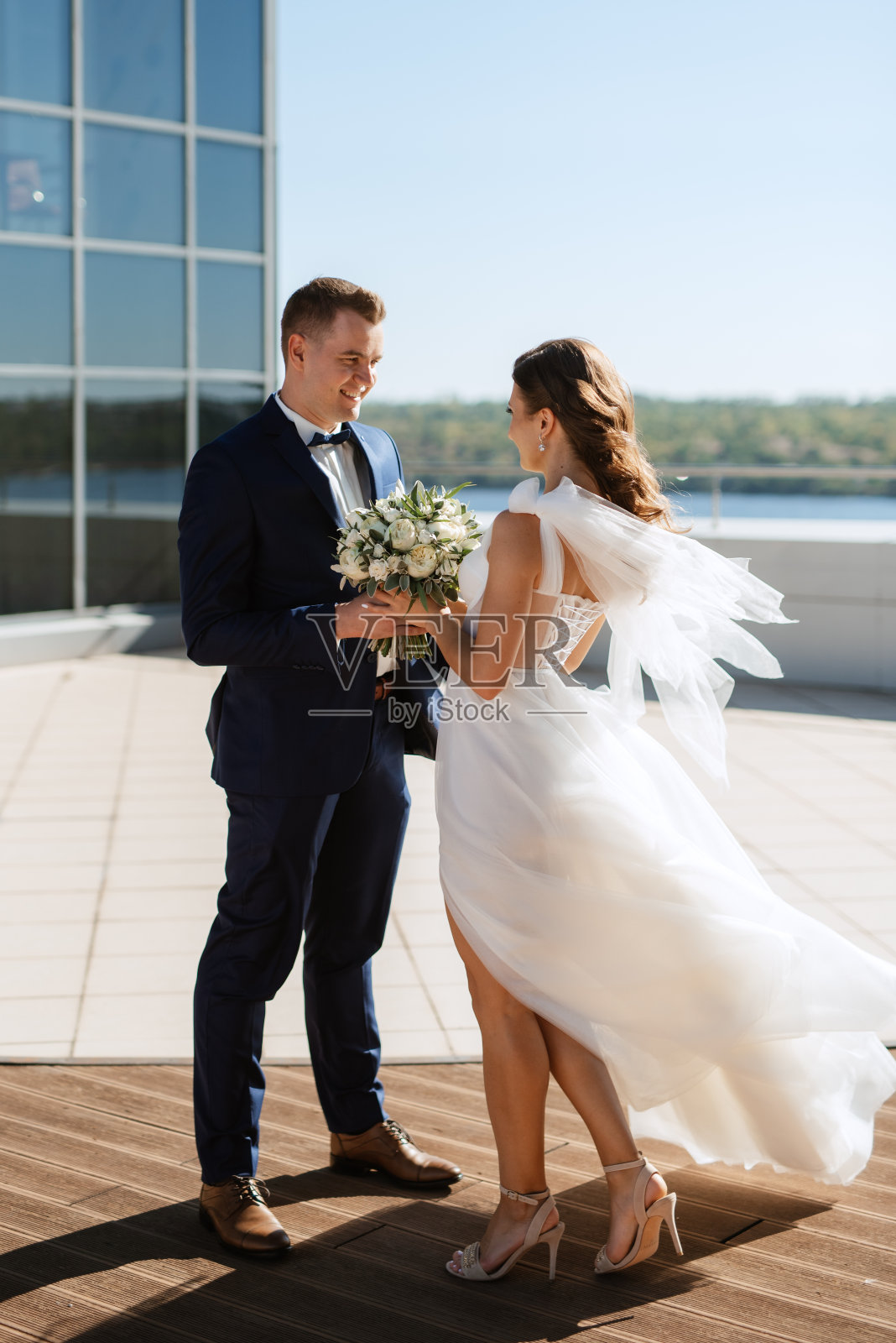 新娘和新郎在摩天大楼的屋顶上第一次见面照片摄影图片