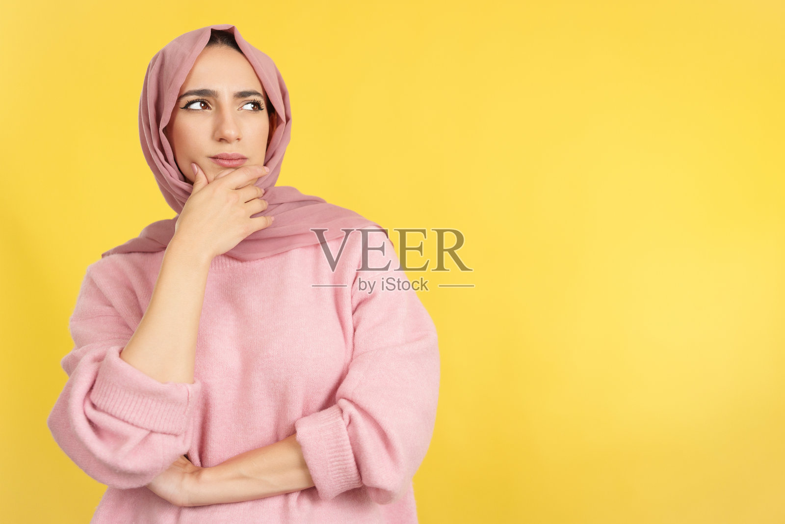 穆斯林妇女，手放在脸上，表情若有所思照片摄影图片