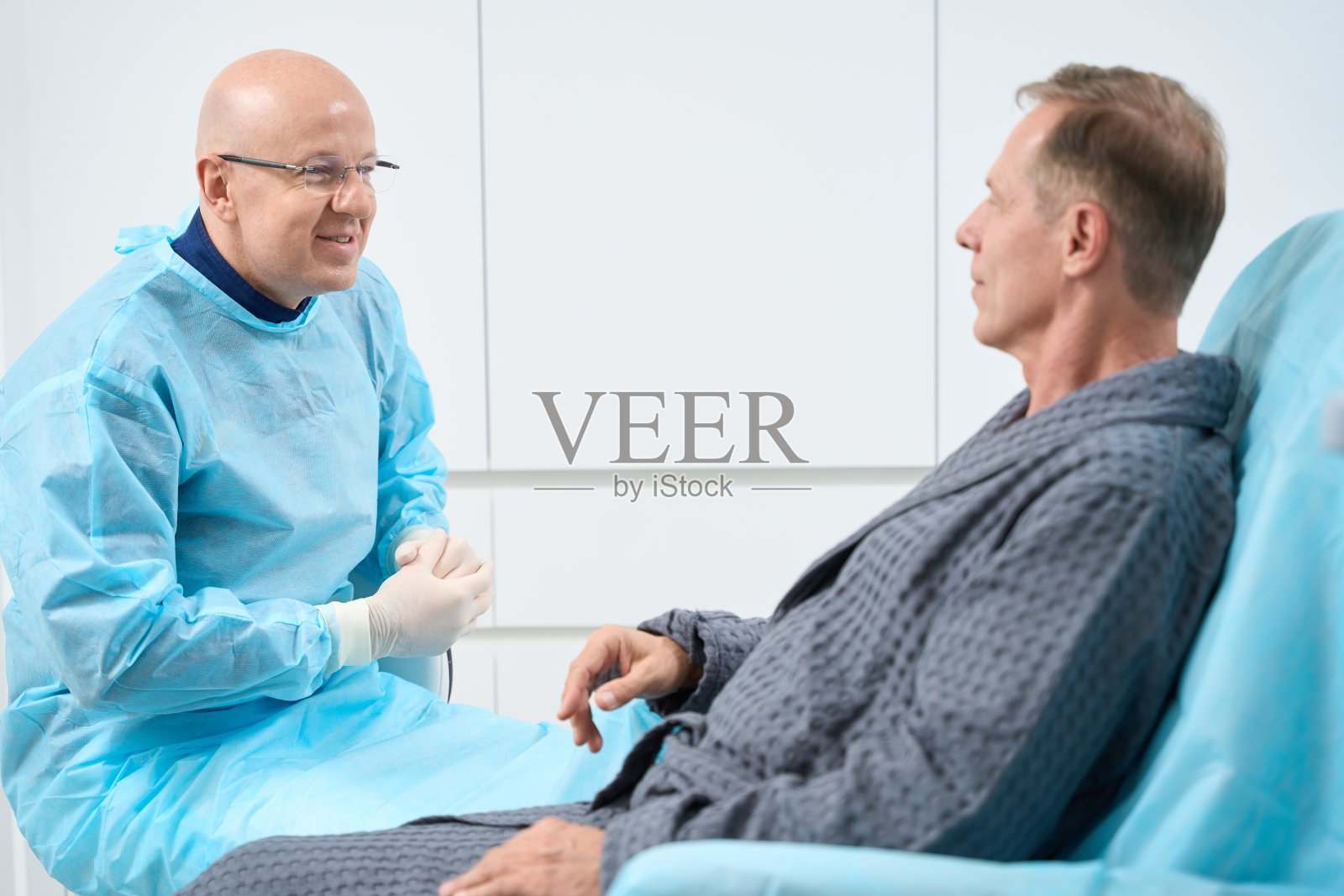 友好的男医生正在和他的病人谈话照片摄影图片