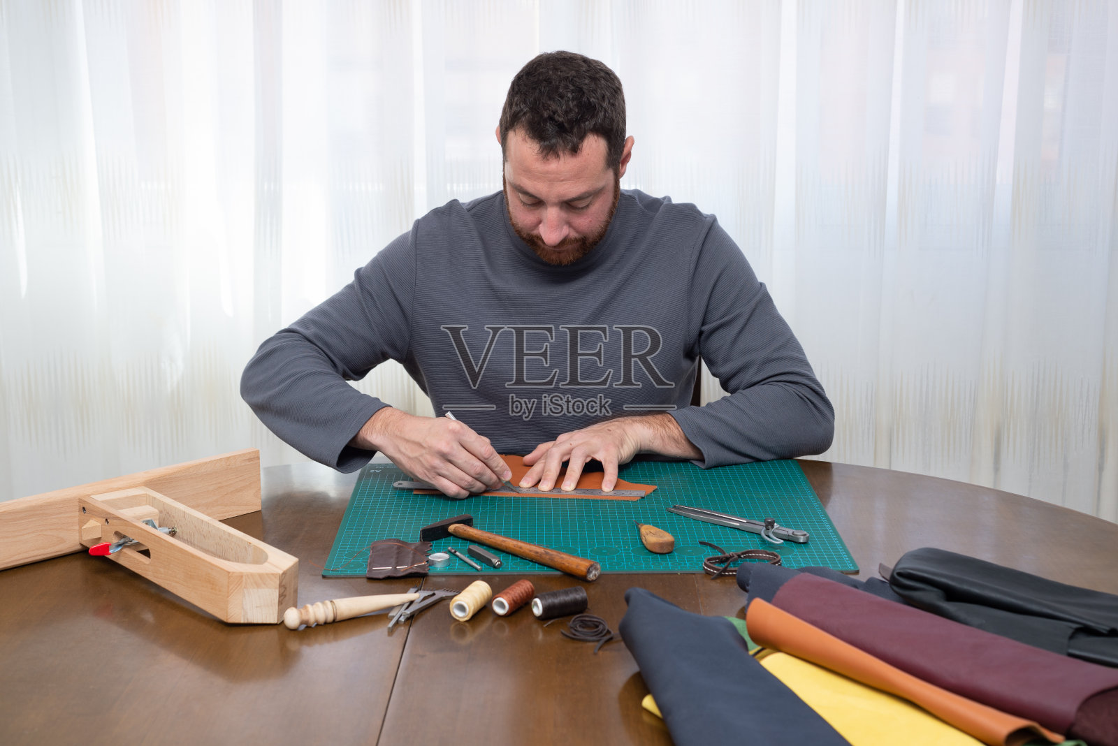 工匠切割皮革。照片摄影图片