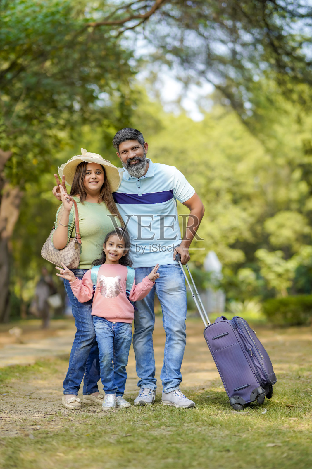 带行李箱的印度家庭。准备好度假了。照片摄影图片