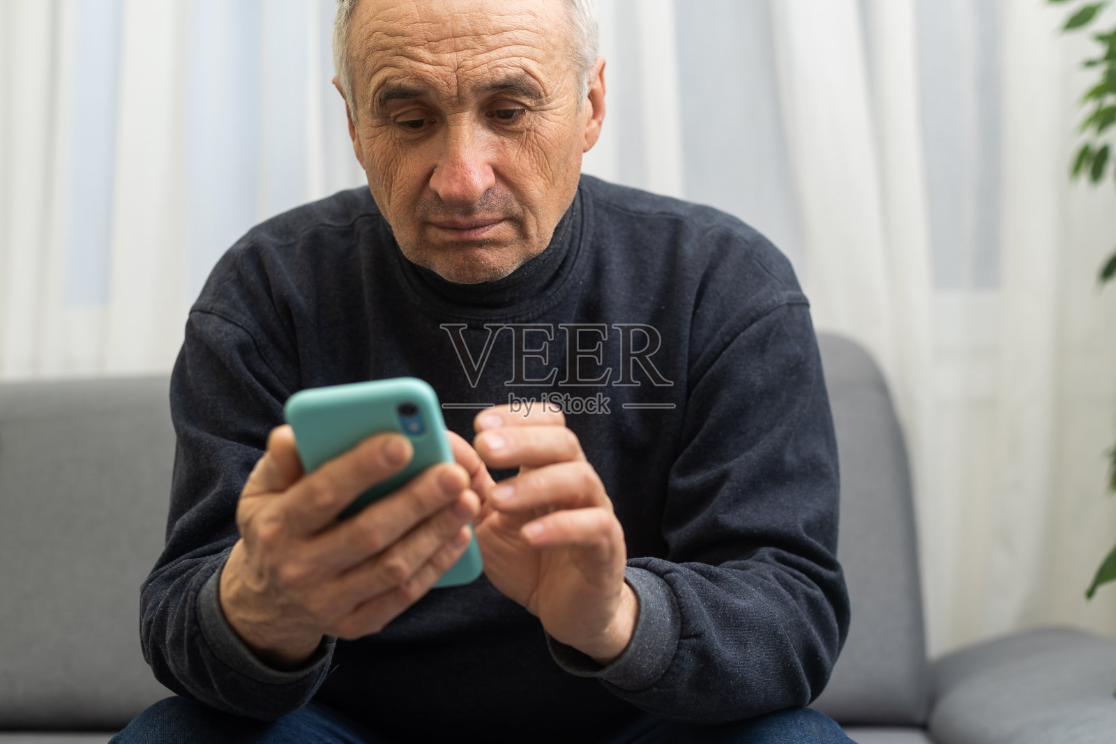 老人使用智能手机，手机在男性手中靠近。退休后在线交流的概念，短信，社交媒体。照片摄影图片