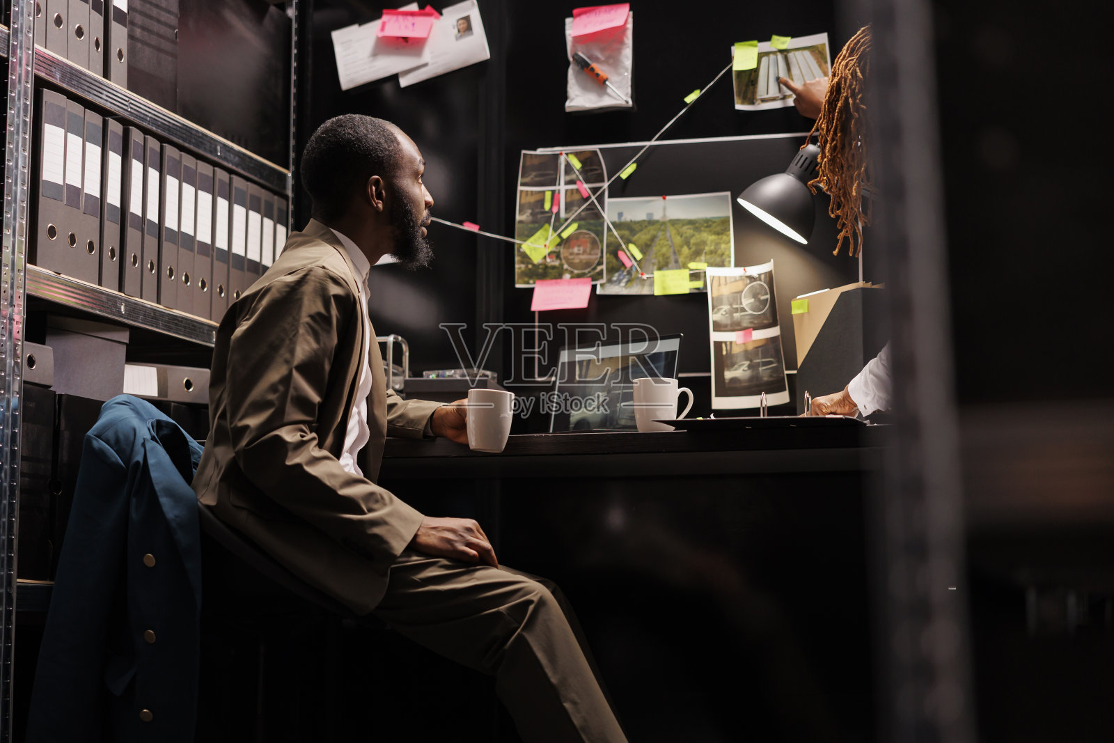 侦探搭档分析证物板上的犯罪现场照片照片摄影图片