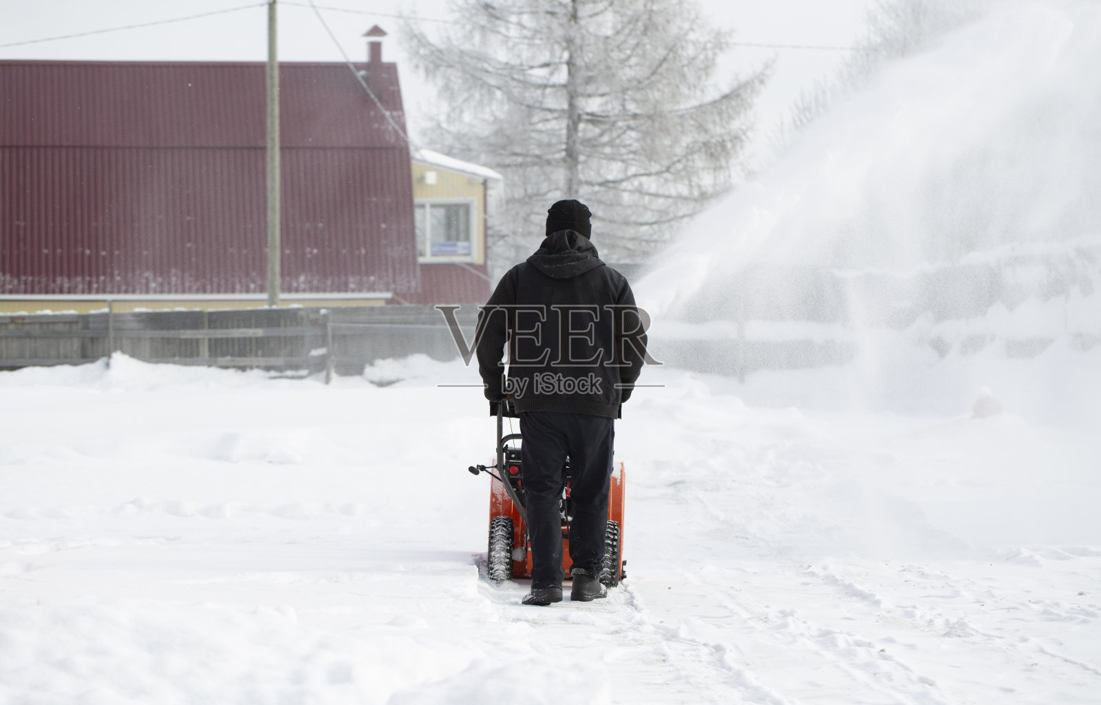 用汽油驱动的便携式吹雪机。照片摄影图片