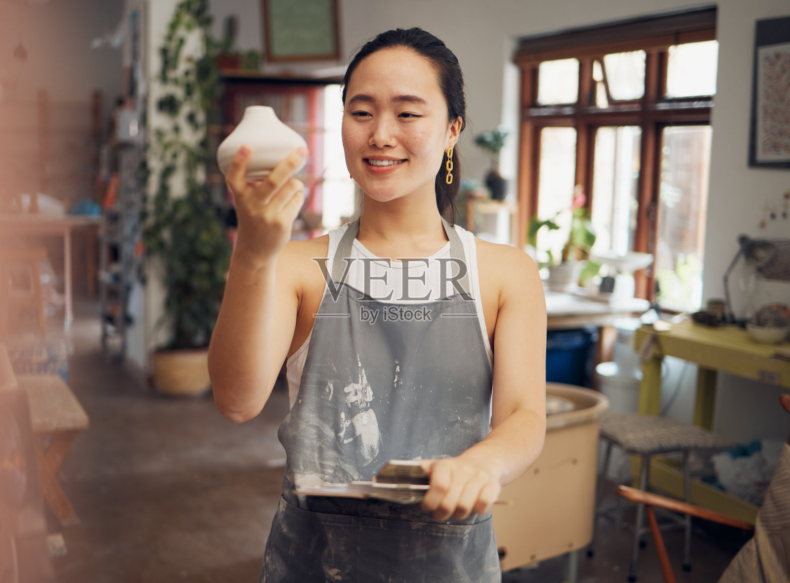 创意，艺术和女人在车间与陶罐，陶瓷和陶器与创意和自豪的工作。快乐的艺术家与纹理，雕刻和创作在手中与剪贴板的产品检查照片摄影图片