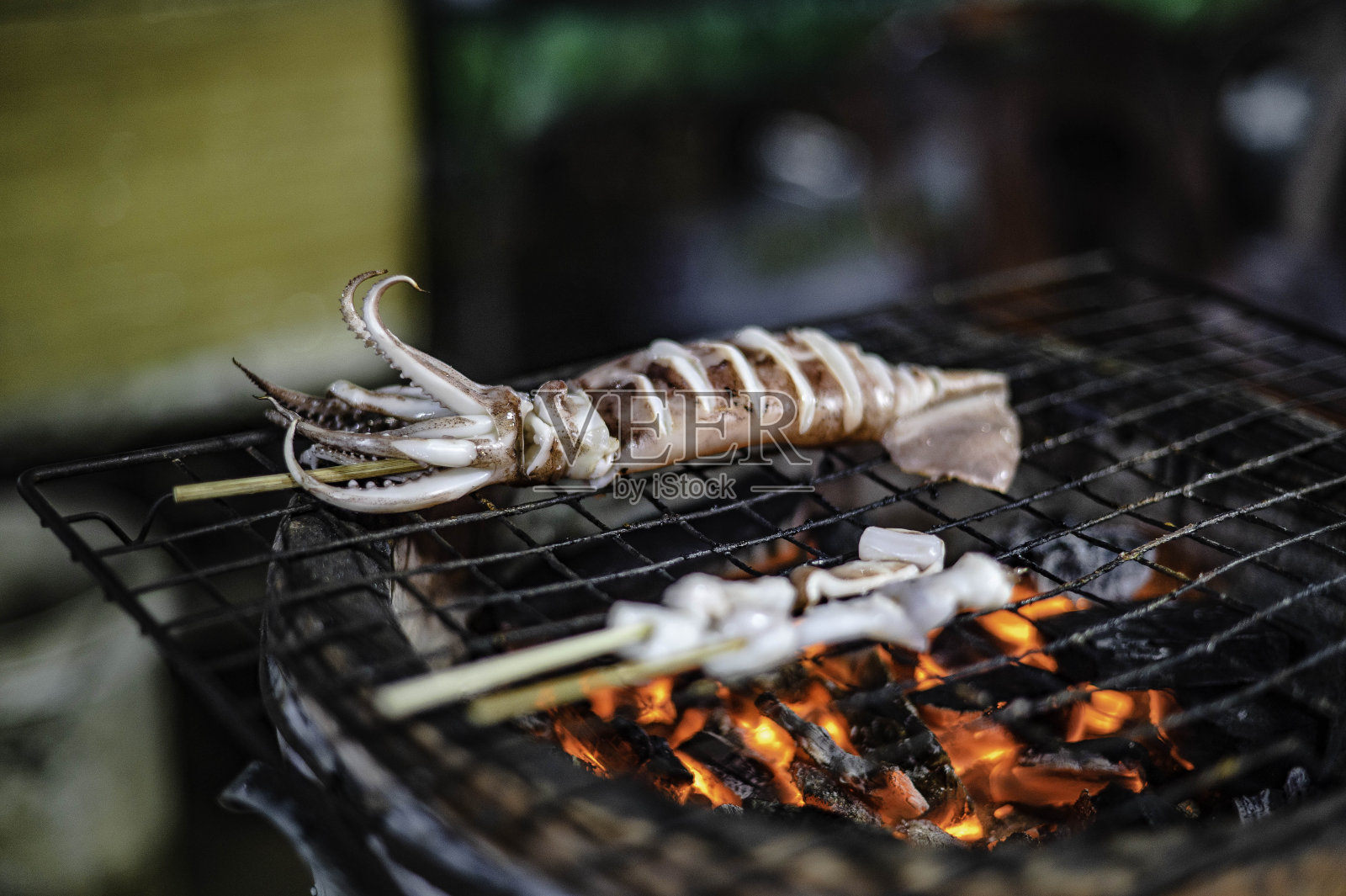 在木炭烤架上烤的新鲜串鱿鱼照片摄影图片