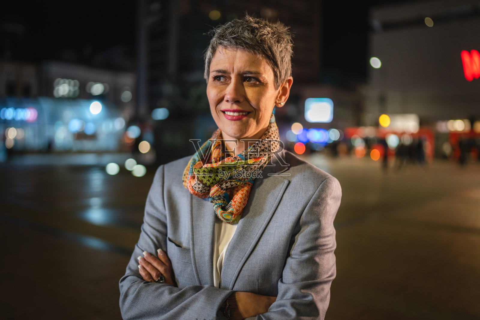 老年妇女的肖像灰色短发站在城市的夜晚照片摄影图片