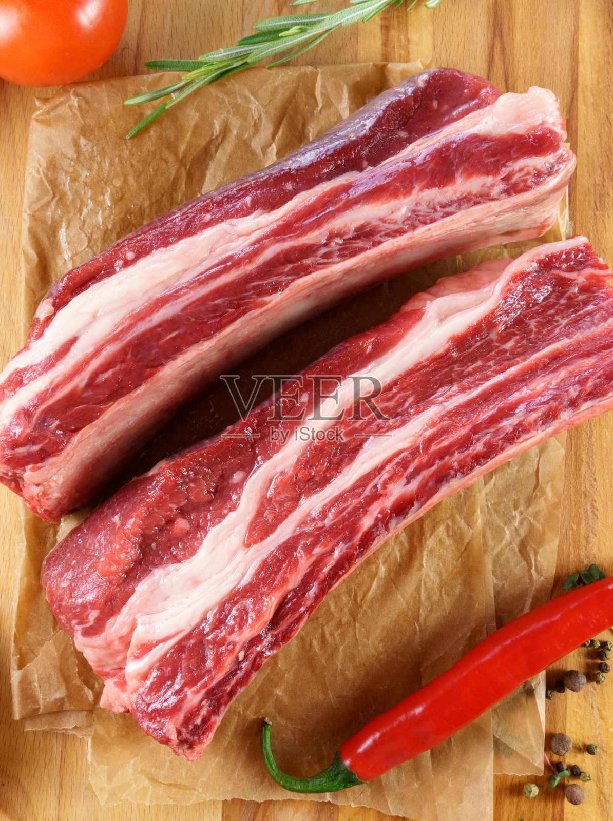 生的战斧牛排在木制背景与香料。烹饪肉类。垂直图照片摄影图片