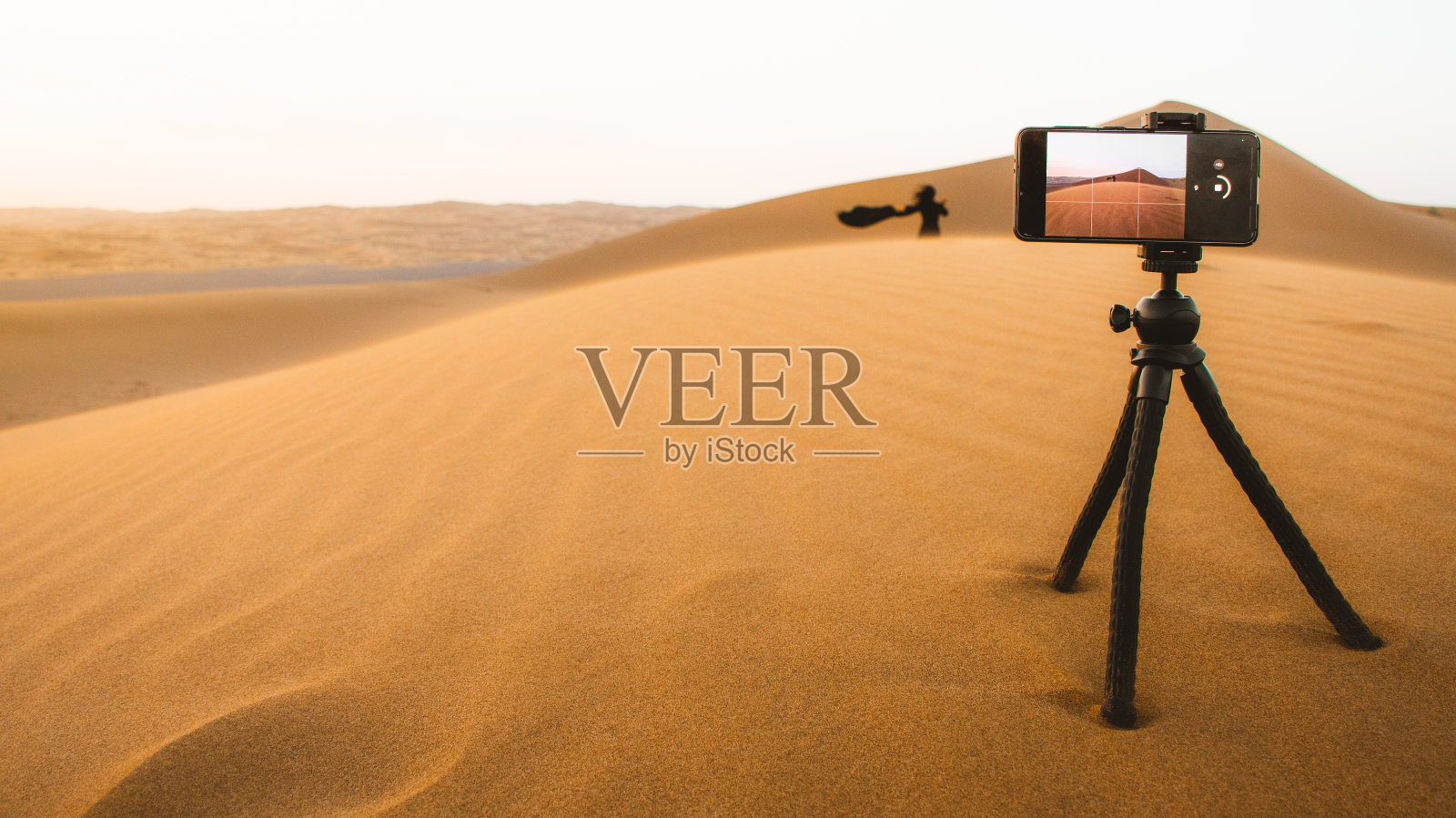 游客走在沙丘上，在伊朗郊外的卡尚沙漠捕捉日落的瞬间照片摄影图片