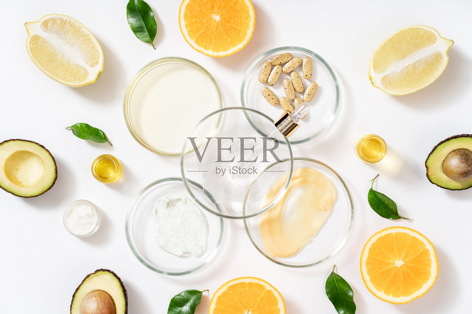 由天然玻璃制成的实验室玻璃器皿，培养皿，化妆品罐，磨砂膏，芳香油。鳄梨油天然美容背景，健康生活方式。照片摄影图片