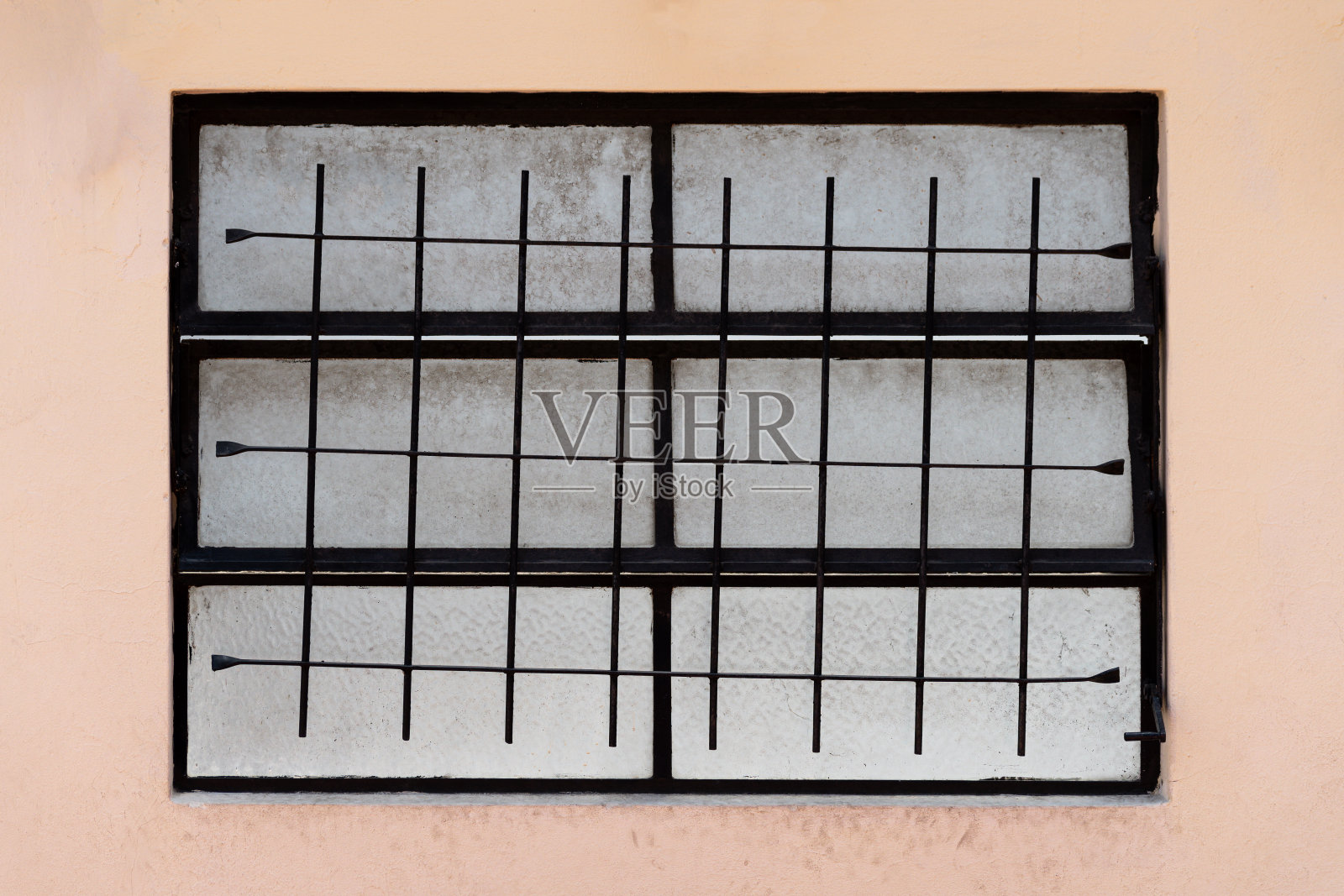 窗户相当脏，焊接格栅弯曲。照片摄影图片