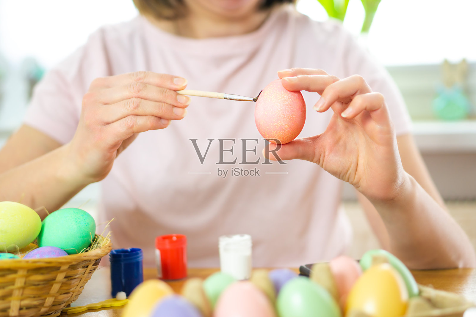 年轻女子喜欢用这些颜色画复活节彩蛋。照片摄影图片