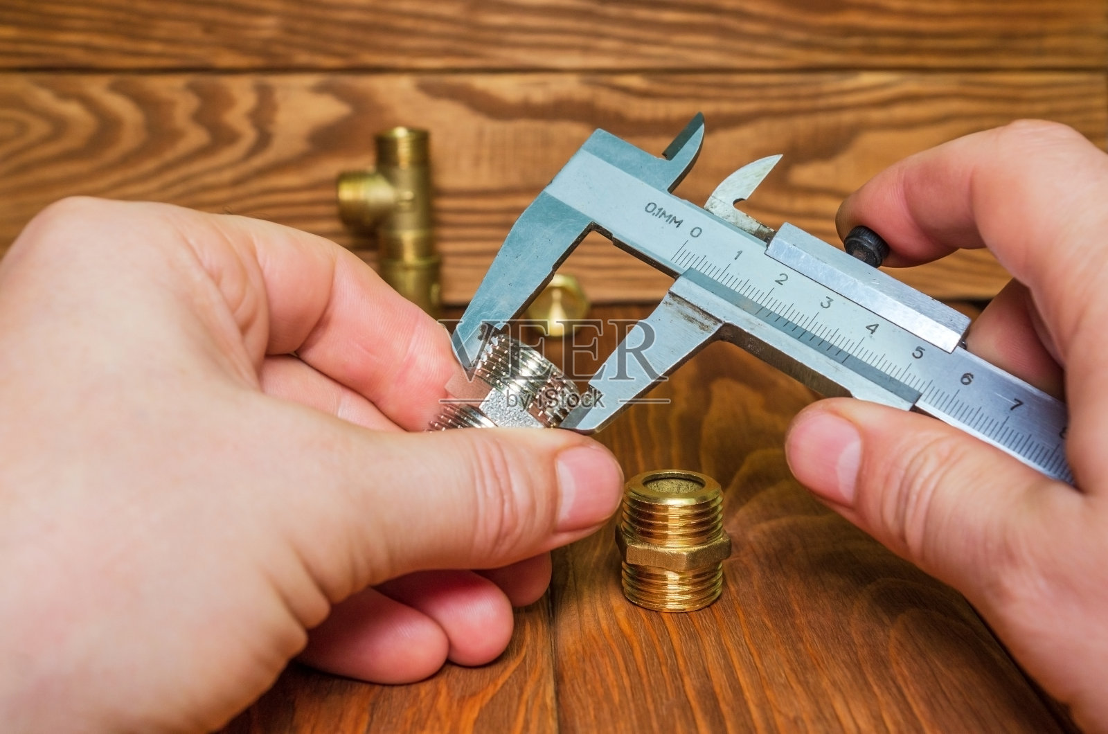 由师傅用卡尺测量管道配件照片摄影图片