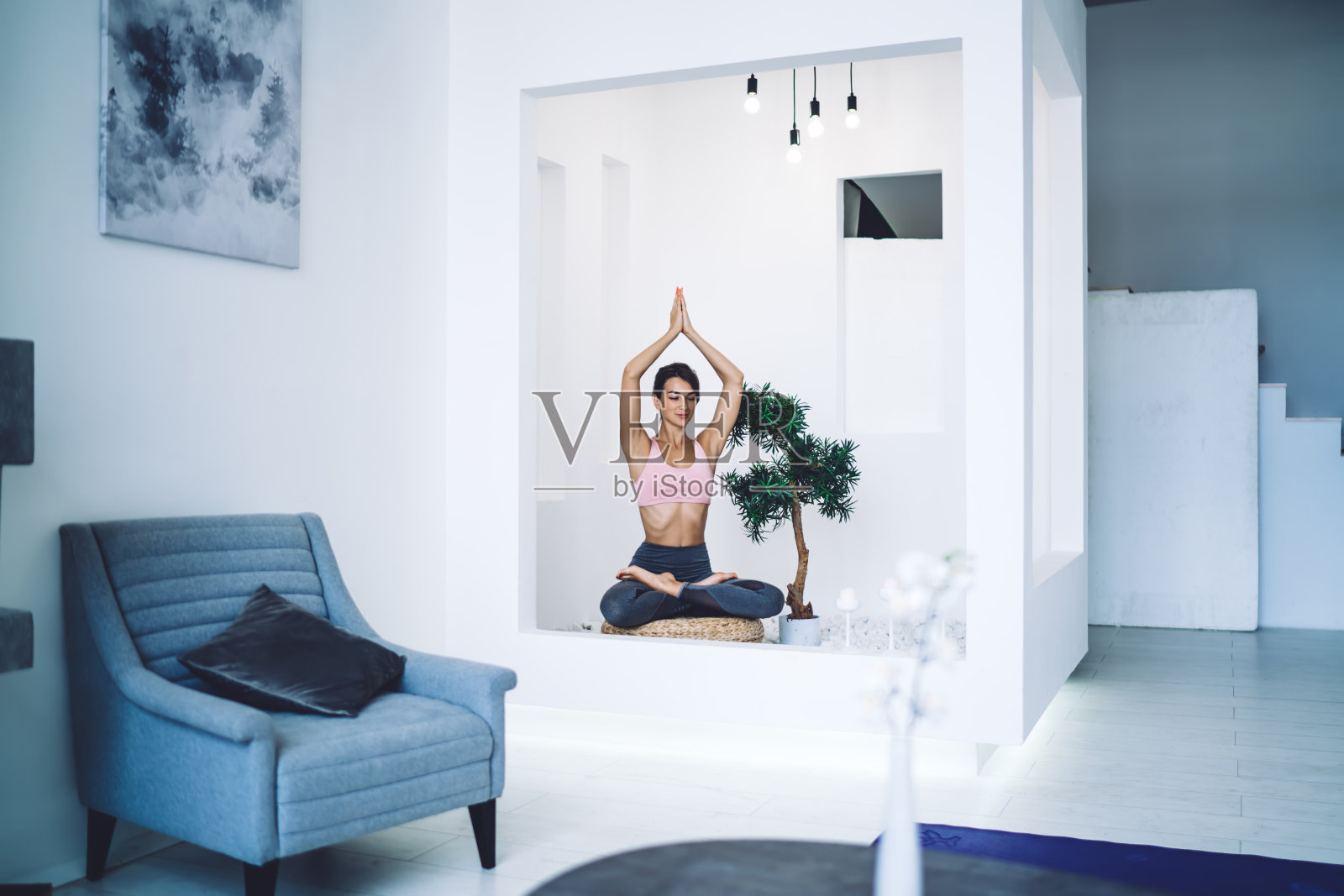 高加索健身女孩坐在公寓里训练活力、健康和宁静，女性穿着休闲运动服，在莲花姿势练习瑜伽，在家里进行冥想照片摄影图片