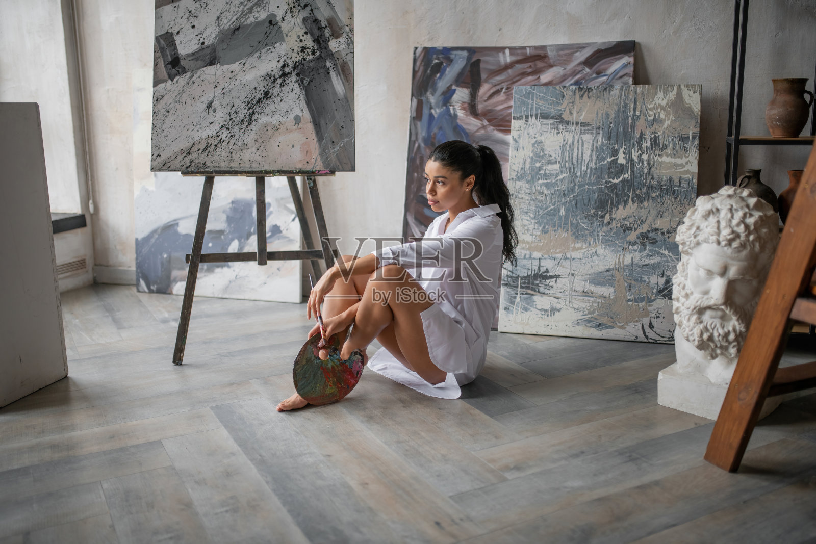 偷拍真实的性感混血女孩在白衬衫对她的画摆姿势的肖像照片摄影图片