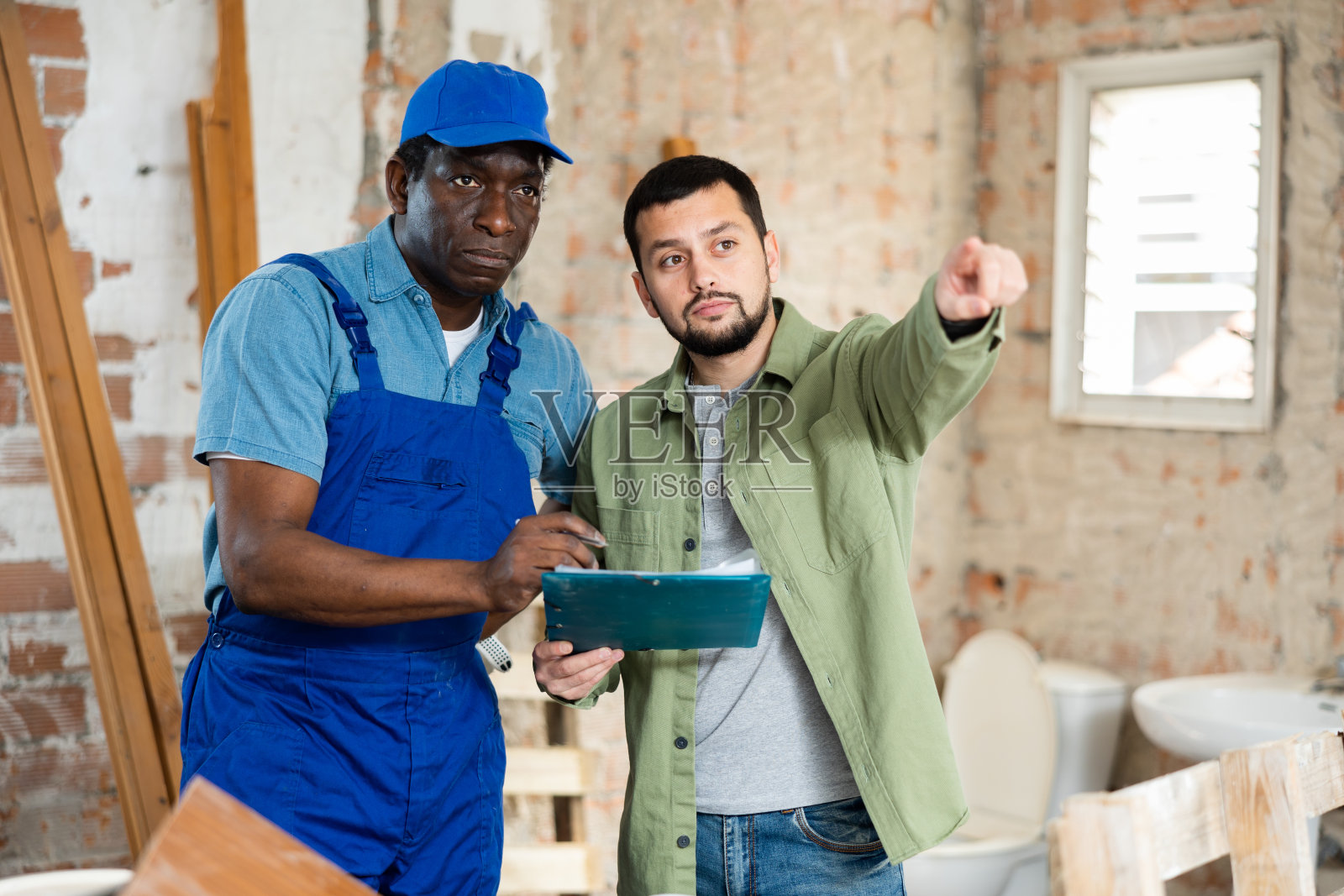 两名男子在室内建筑工地交谈照片摄影图片