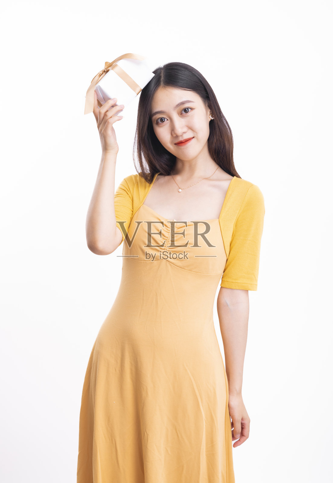 一个穿着黄色连衣裙的女人拿着礼品盒照片摄影图片