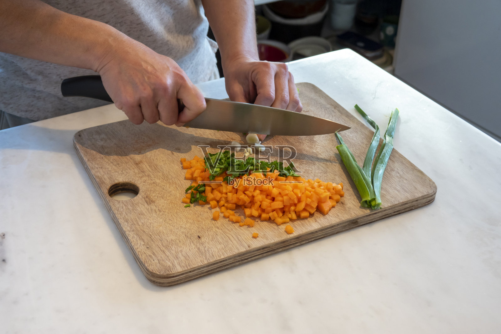 手在木砧板上切葱的特写镜头照片摄影图片